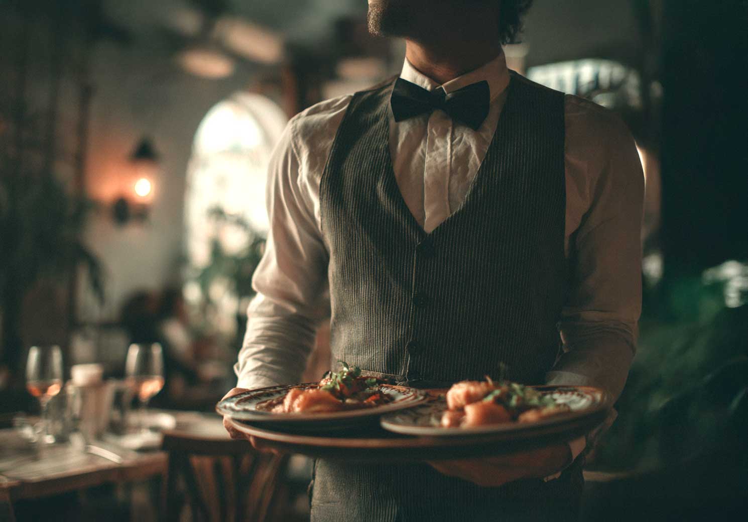 Cameriere che serve gli ospiti durante un evento elegante organizzato da Buratti Catering nelle Marche